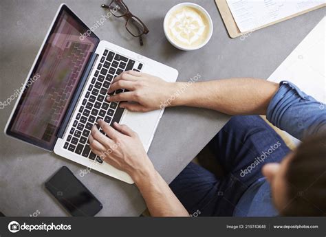 Caucasian man using laptop in a coffee shop, overhead shot - Competenza Formation