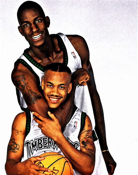 two basketball players hugging each other with tattoos on their arms and chest, both holding a ...