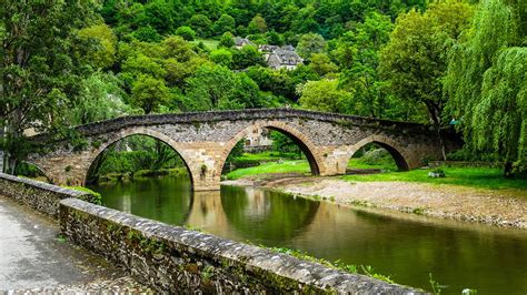 Belcastel medieval stone bridge across Aveyron river with forest ...