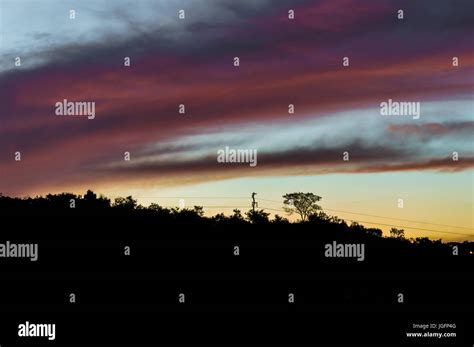 Silhouette of a hill during a multicolored sunset Stock Photo - Alamy