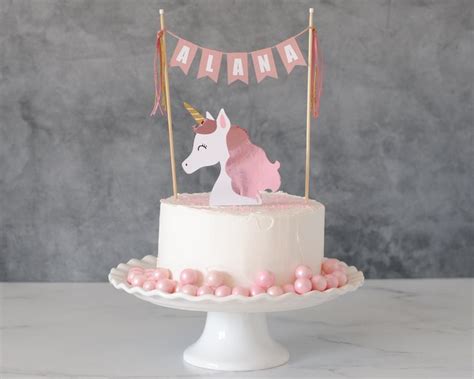 a pink and white cake topped with a unicorn topper