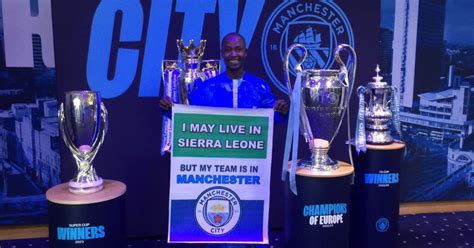 Sierra Leonean Man City Fan, Armani, Poses with Club's Trophies