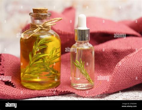 Bottle and dropper with rosemary oil with fresh twigs inside on a red cloth Stock Photo - Alamy