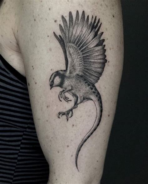 Micro-realistic hybrid bird/lizard tattoo on the upper