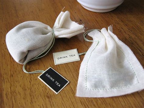 a tea bag sitting on top of a wooden table next to a cup and tag