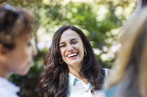 Woman laughing while standing by friends stock photo