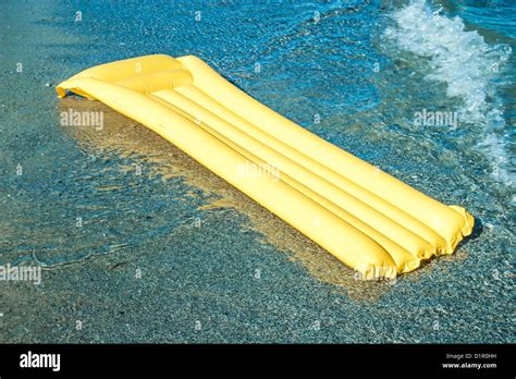 Yellow Floating air mattress on the beach Stock Photo - Alamy