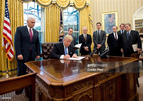 U.S. President Donald Trump signs the first of three Executive Orders ...