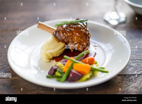 A lamb shank with mashed potato and vegetables on a plate Stock Photo: 95367287 - Alamy