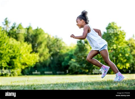 Little girl running in park, smiling Stock Photo - Alamy