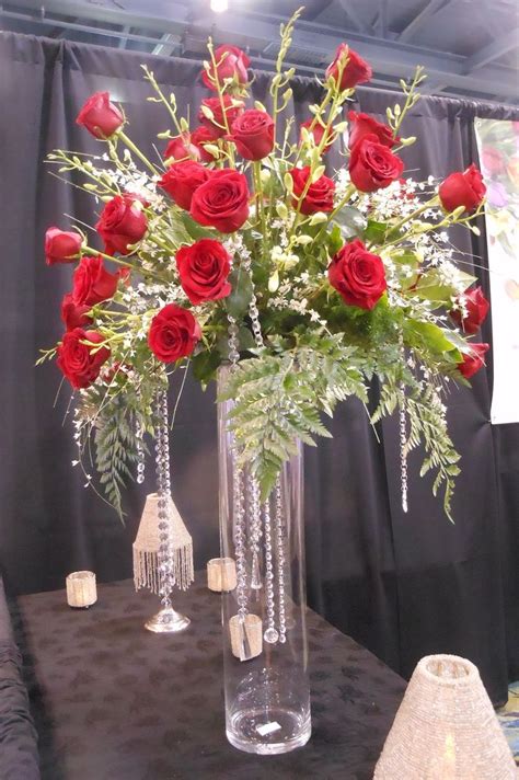 , head table arrangements. red rose arrangement on a tall glass vase ...