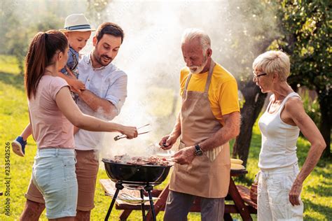 Family enjoying bbq party in their garden Stock Photo | Adobe Stock