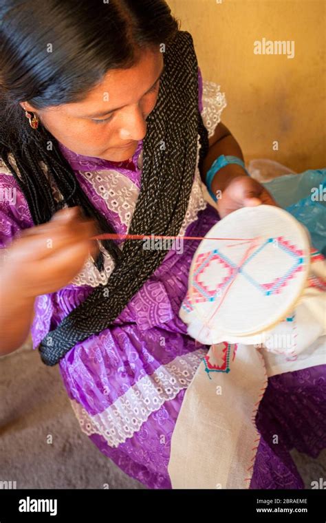 Une femme artisanale crosse un dessin pour un chemisier traditionnel à San Vicente Coatlan ...