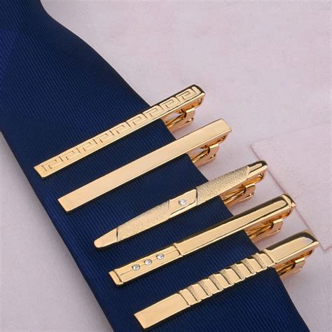 four different types of gold hair clips on a blue tie