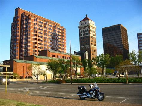 a motorcycle parked on the side of a road in front of tall buildings ...