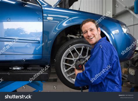 Male Mechanic Wearing Blue Overalls Attaching Stock Photo 1807085629 ...