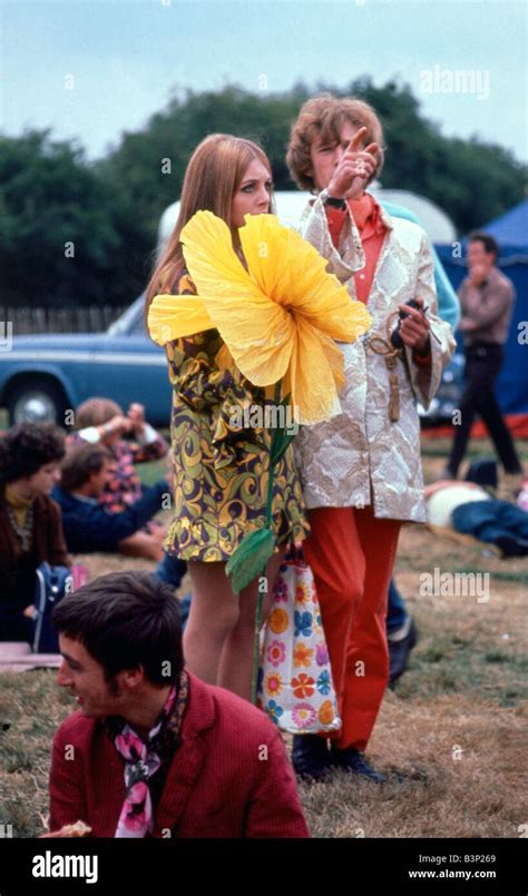 Sixties fashion 1960s Festival of the Flower Children Hippy hippies with giant large yellow ...