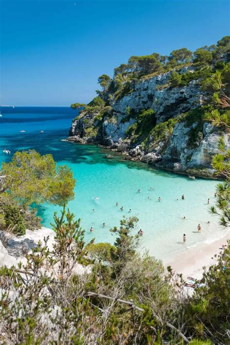 people are swimming in the clear blue water at an island with white ...