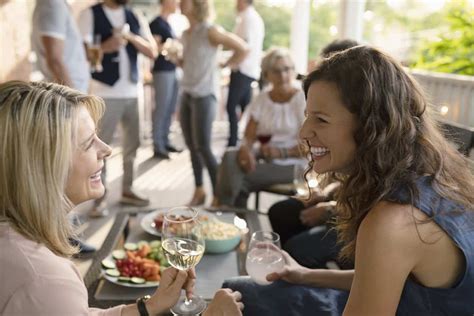 Happy women friends talking and drinking wine on summer porch - McKissock Learning