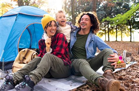 young happy family portrait camping outdoor with tent in autumn nature ...