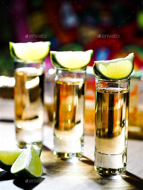 Three shots of tequila in tall shot glasses Stock Photo by alexbowmore