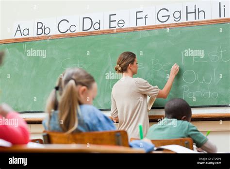 Teacher writing on board Stock Photo - Alamy