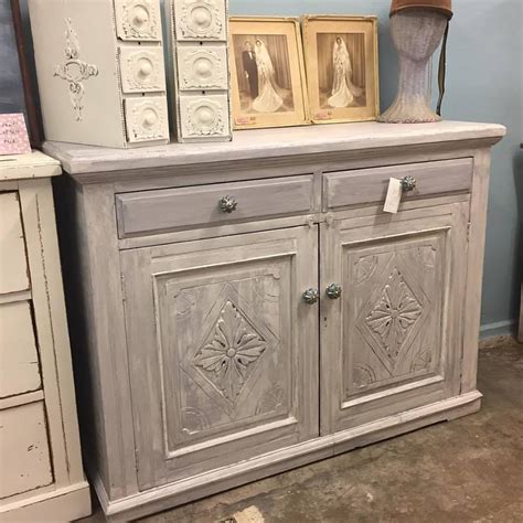 an old dresser with some pictures on top