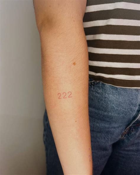 Tattoo of the number "222" in red ink located on the