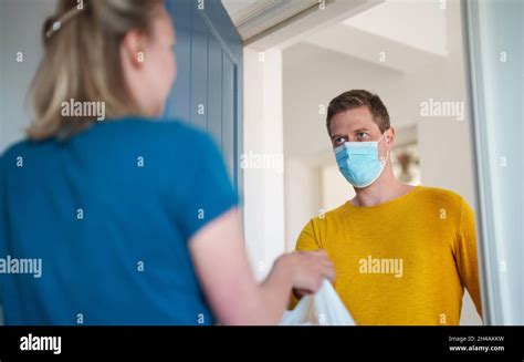 Masked man delivers food during pandemic Stock Photo - Alamy