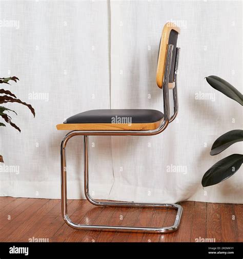 A black vinyl and chrome cantilever chair. Elegant Mid-Century Modern furniture. Interior ...