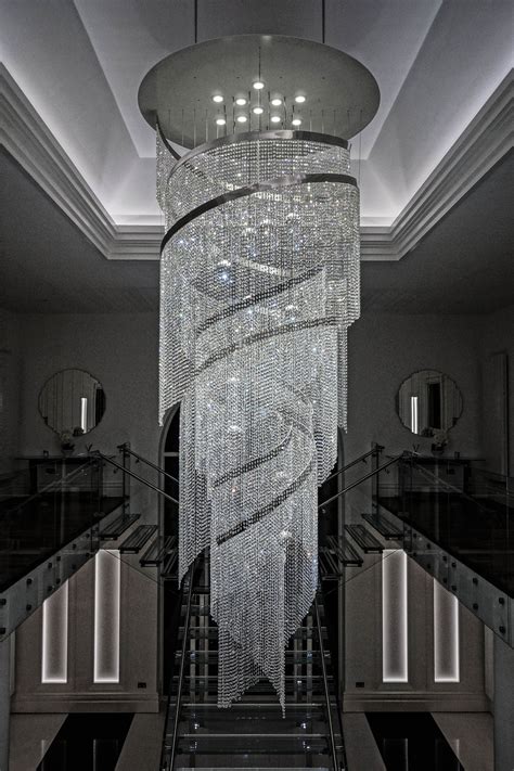 a large chandelier hanging from the ceiling in a room with stairs and ...