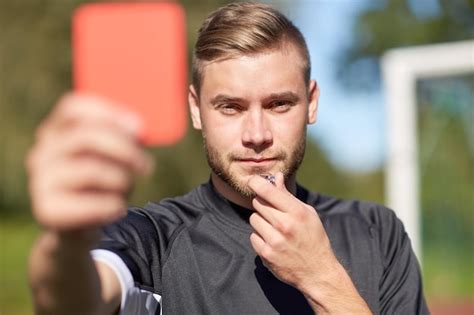 Premium Photo | Sport, caution, game and people - referee with whistle showing red card on ...