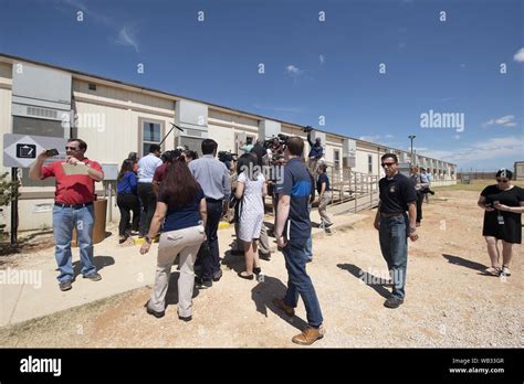 Dilley, Texas, USA. 23rd Aug, 2019. National Media walk outside in the 100 degree heat during a ...