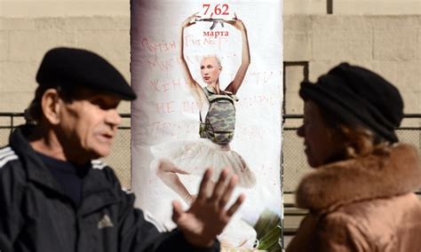 Vladimir Putin on a poster as a dancing ballerina wearing a bulletproof vest with Kalashnikov ...