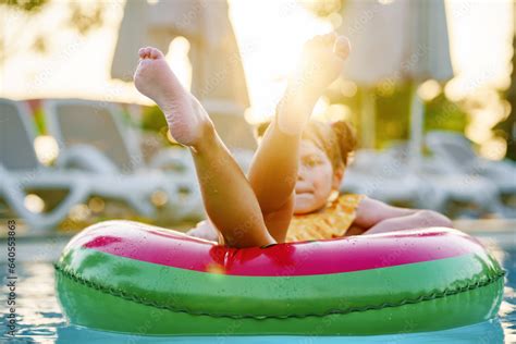 Happy little girl with inflatable toy ring float in swimming pool ...