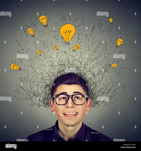 Brain connections. Excited man with many ideas light bulbs above head looking up isolated on ...