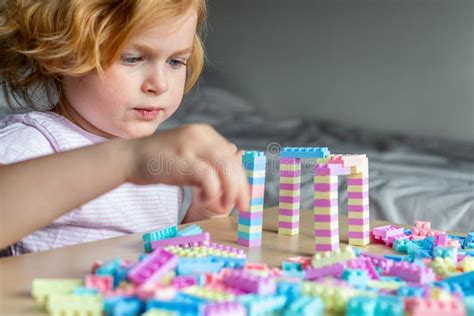 Small Cute Preschooler Girl Playing with Colorful Toy Building Blocks, Sitting at the Table ...