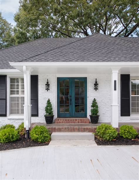 white brick house with wood shutters - Valda Hurst