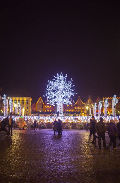 Lit up ice rink and Christmas Market in the Markt in Brugge (Bruges), Belgium in winter for ...