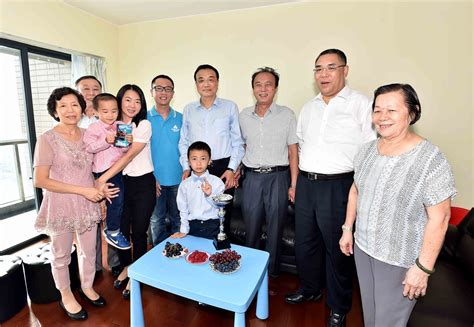 Premier li keqiang visits a family in macao, signs on the back of their family photo - scoopnest.com