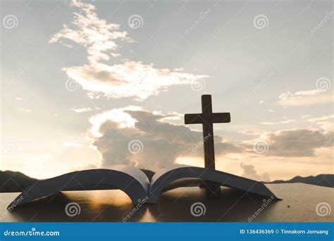 Open Bible, Script in Blur with Focus on Palm Cross,on Sunrise Background, Crucifix, Symbol of ...