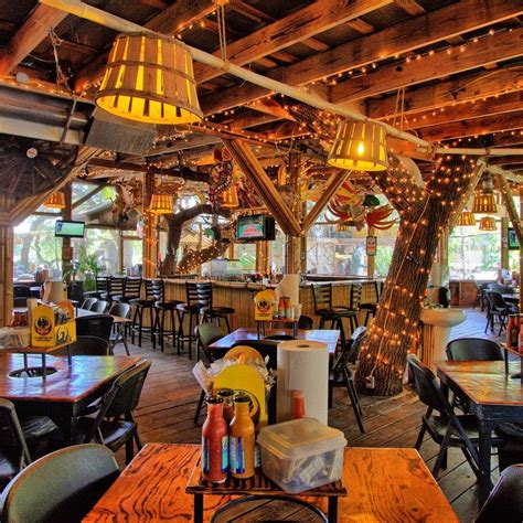 the inside of a restaurant with tables, chairs and lights hanging from the rafters