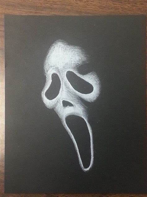 a chalk drawing of a scream mask on a blackboard with white paint and the mouth open