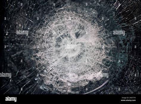 Bulletproof glass after test. bulletproof glass with cracks and a crater from a bullet hit ...