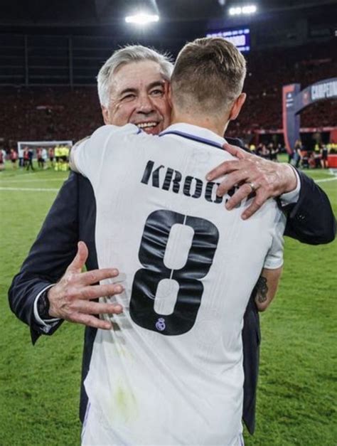 two men hugging each other on a soccer field