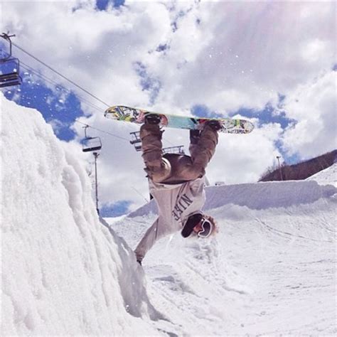 a man riding a snowboard down the side of a snow covered slope