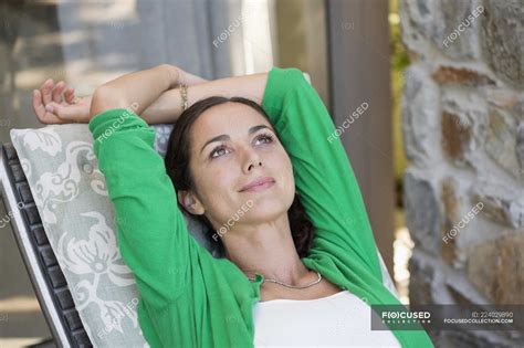 Thoughtful woman relaxing on lounge chair — lifestyle, smiling - Stock ...