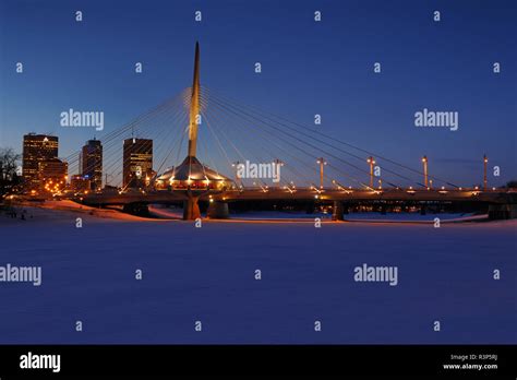 Canada, Manitoba, Winnipeg. Winter skyline and Esplanade Riel Bridge at ...