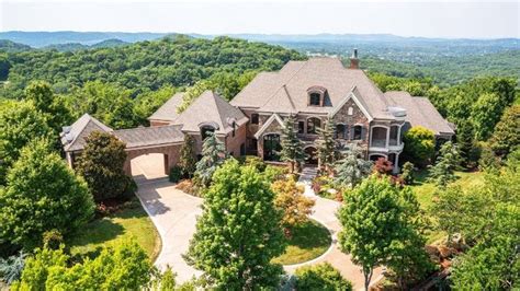 an aerial view of a large home surrounded by trees