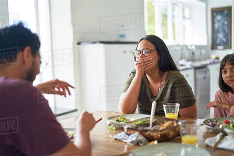 Happy family laughing at dinner table - Stock Photo - Dissolve